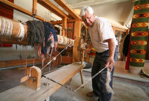 Porfirio Santiago spins wool into yarn to warp his traditional loom. The master weaver creates stunning Zapotec rugs in his Teeotitlan del Valle workshop in Oaxaca. © William Ing, 2007