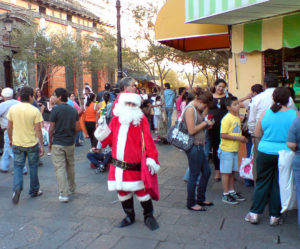A skinny Santa Claus competes for attention with an ice cream shop in the downtown historical section of Guadalajara. © Daniel Wheeler 2009
