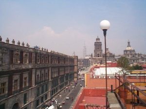 Looking west from the roof of the Hostel Moneda, the huge National Palace is on the left, then the distant Latin America Tower is center, and then to the right are the towers of the Cathedral.