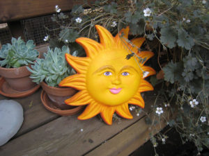A bright yellow Mexican ceramic handcrafted sun adds year-round cheer to a wooden deck somewhere around the 46th parallel. © Julia Taylor, 2008