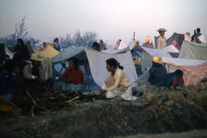 Each night, the masses camp beside the highway, wherever darkness falls. Improvised shelters provide only meagre respite for aching bones after each day's arduous hike.