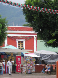 Decorations for Independence Day brighten the zocalo in Tepoztlan. In the center, a news stand entices shoppers with a colorful display of magazines and comic books. © Julia Taylor 2007
