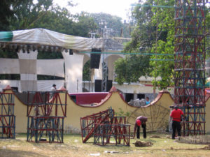 Assembling the castillo. The stage where the band will play is beyond the churchyard wall to the left and the mechanical rides and food stands to the right. © Julia Taylor, 2007