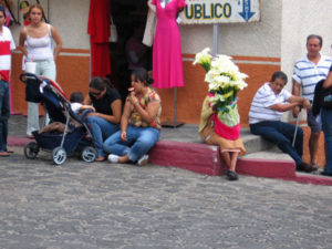 Weary shoppers sit down for a moment on well-swept sidewalks. A woman selling fresh calla lilies hides shyly behind her bouquet at the sight of a camera pointed in her direction. © Julia Taylor 2007