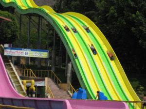 Daring swimmers on inner tubes race head first down the six-lane water slide to end the ride with a cooling splash in the shallow pool at the end of this popular ride at El Rollo in Morelos, Mexico. © Julia Taylor, 2008