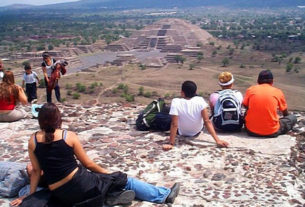 Tourists sit atop the Pyramid of the Moon in Teotihuacan to contemplate the majestic Pyramid of the Sun. This archeological zone is located outside Mexico City. © Rick Meyer, 2001