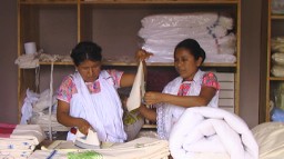 Two members of the cooperative working on the new line of linens in the workshop.