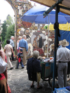 A woman n a blue rebozo woman sells homemade ice cream in front of Tepoztlan's seed archway. © Julia Taylor 2007