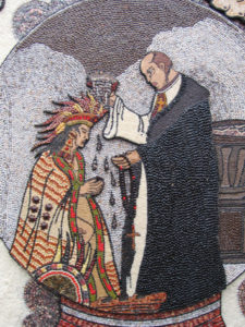 Depicted on the seed archway, a priest baptizes one of the first indigenous converts to Christianity, who kneels to receive the sacrament. © Julia Taylor 2007