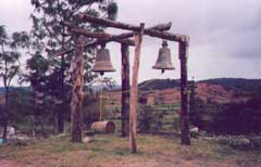 These bells were removed from the church at Santa Maria Tiltepec. An earthquake caused severe structural damage to the bell tower in June of 1999. Erosion caused the red gashes in the surrounding hills. The church will be restored, but the soil will not. © Diana Ricci, 1999