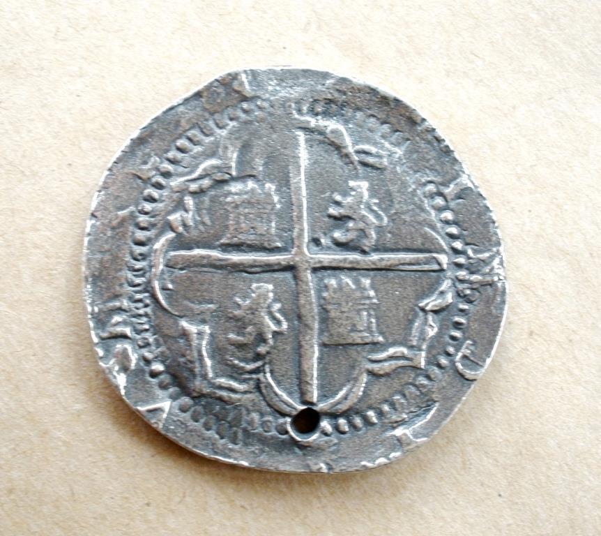 The reverse of a Spanish sixteenth century Ocho Real coin showing the castles of Castille and lions of León representing a united Spain of King Ferdinand & his Queen Isabella.