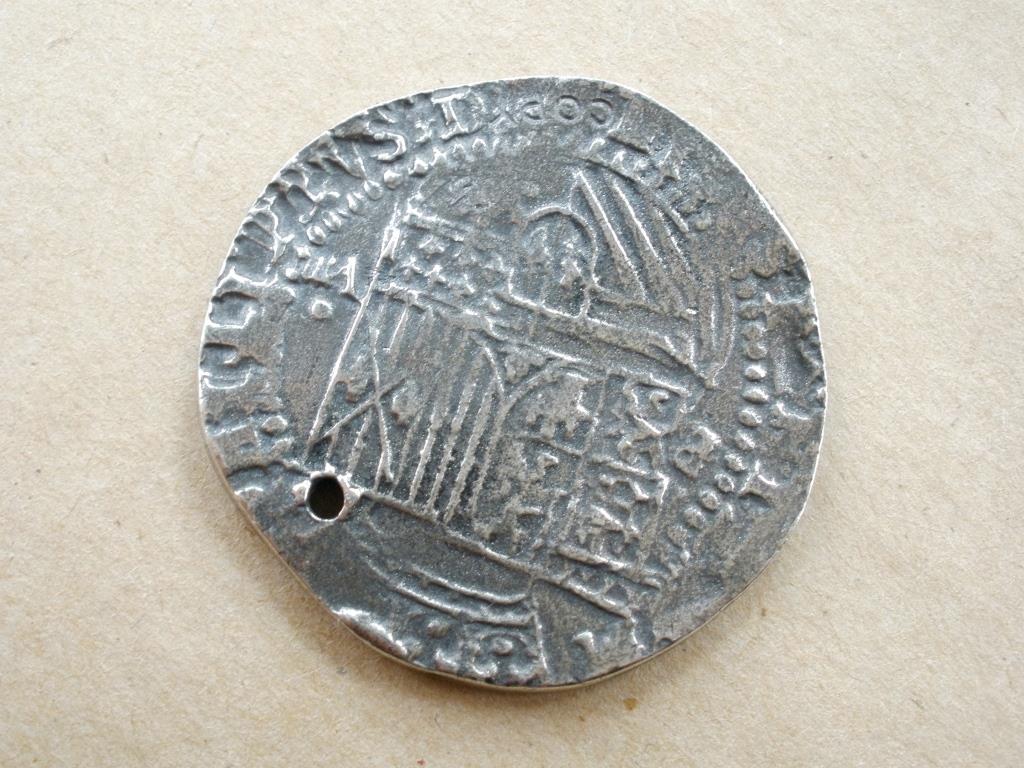 replica of a Spanish 16th Century eight Real coin or piece-of-eight, the type that would have been minted in upper Peru (now Bolivia). Coins like these were brought by the treasure galleons to the Philippines for trade. 