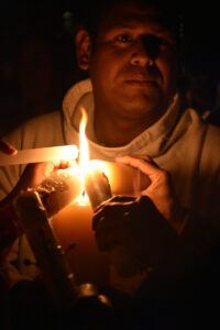 Saturday night, Nuevo Fuego. The síndico holds a large candle from which people light theirs. © Joseph Sorrentino, 2023