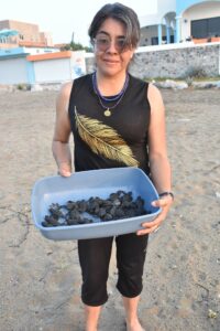 Resort guest Martha C. holds a tub of babies prior to their release. © Joseph Sorrentino, 2022