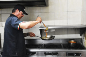 Guiseppe (Pepe) Merlo preparing Cremini de Aglio Pomodoro. © Joseph Sorrentino, 2023