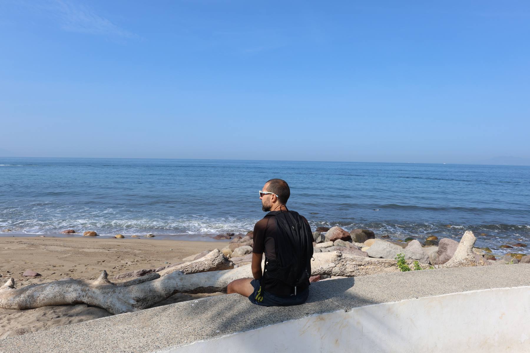 Sitting on Puerto Vallarta malecón. © Florence Voller, 2025.